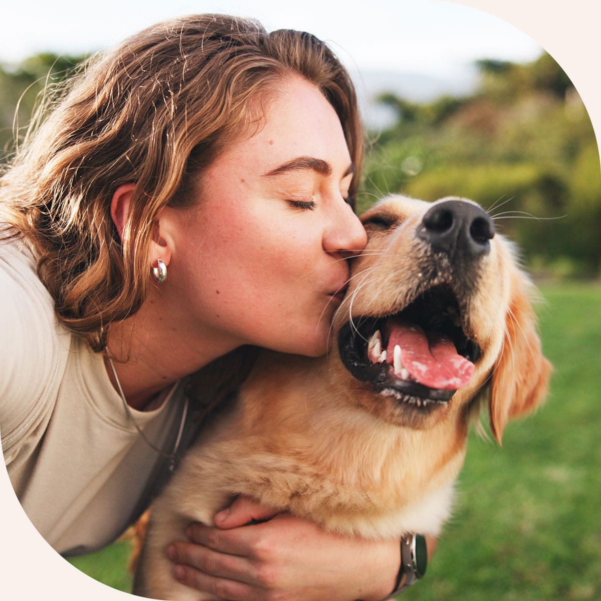 Woman kisses her healthy dog once she gets the results back from a veterinary X-ray